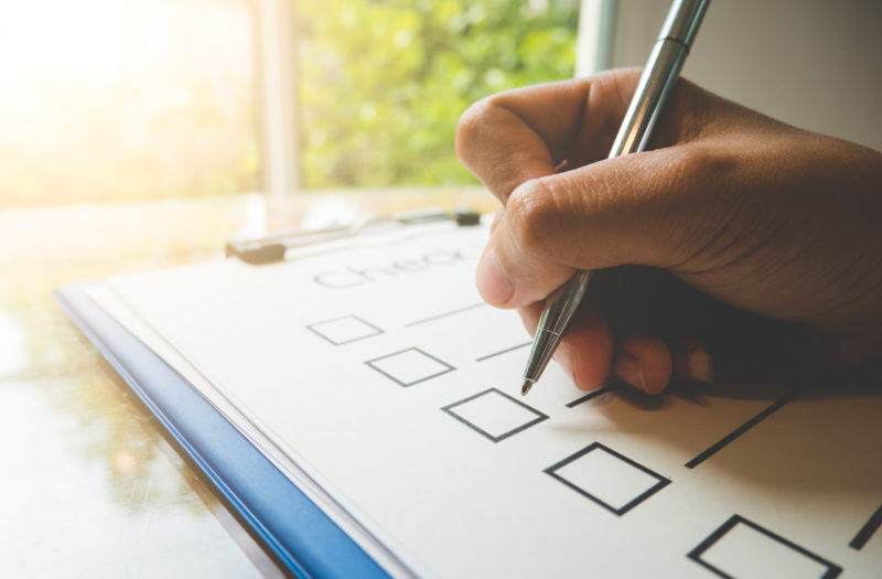hand holding pen on to-do list